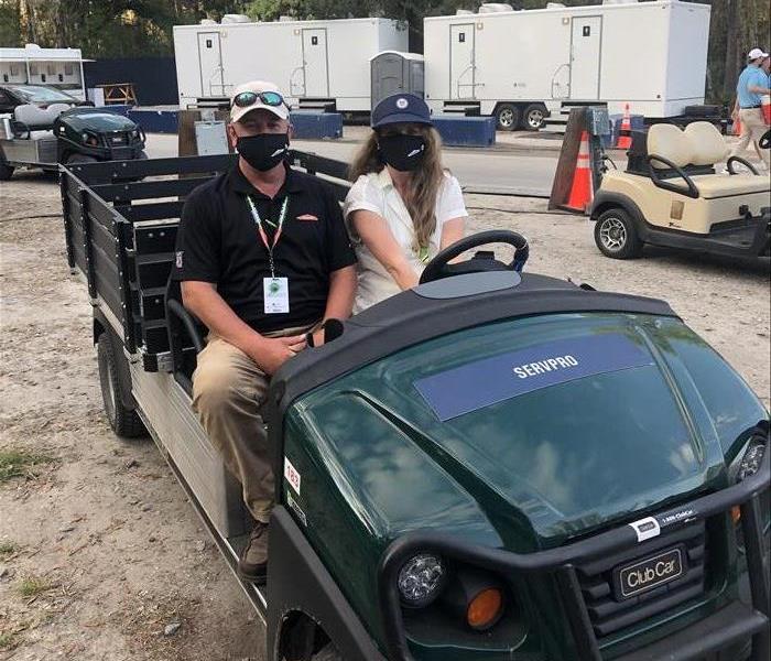 Image shows two SERVPRO employees in a vendor golf cart.
